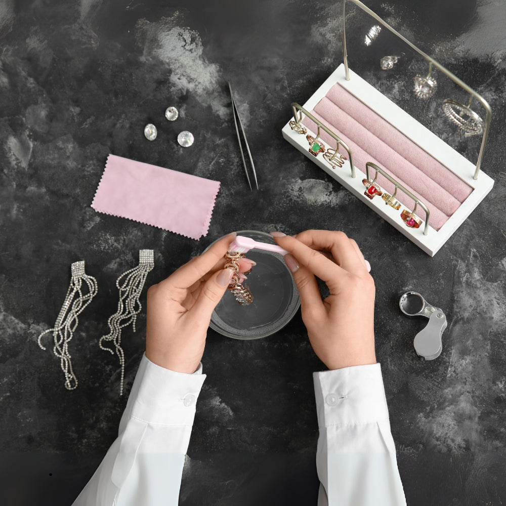 A woman using a brush to gently care and clean her sterling silver jewelry and handcrafted gemstone jewelry.