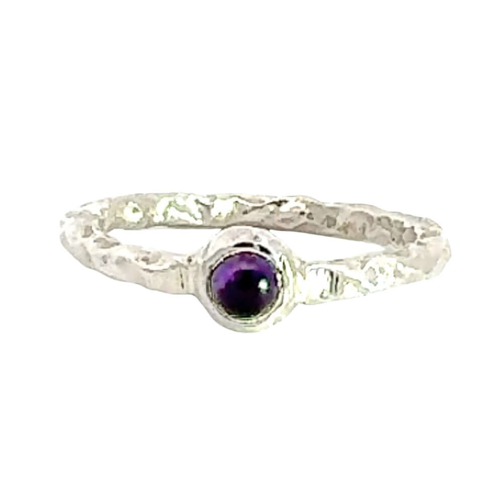 Silver ring with a purple gemstone on a white background