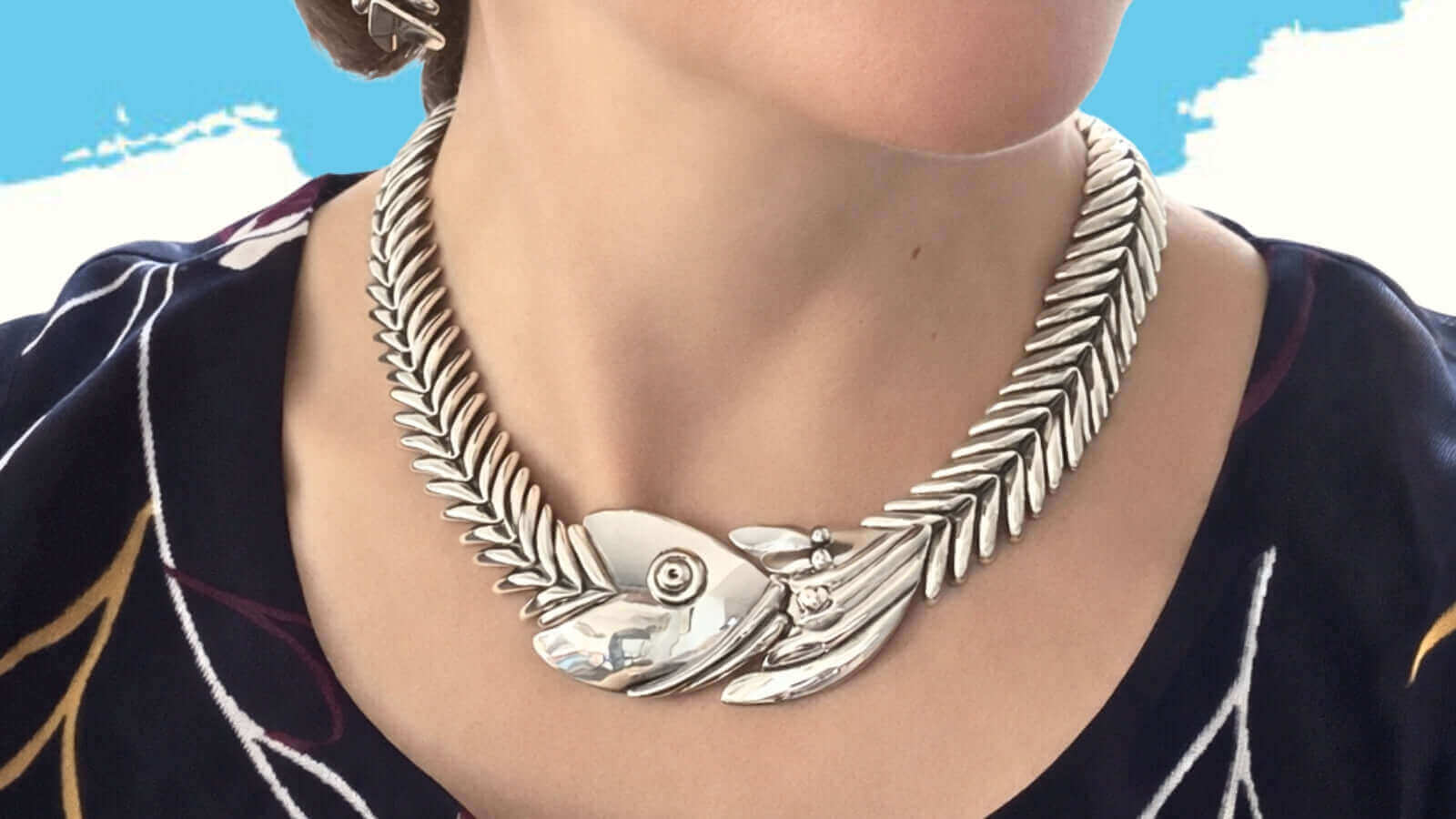 Close-up lifestyle view of a woman wearing the iconic D'Molina articulated sterling silver fishbone necklace