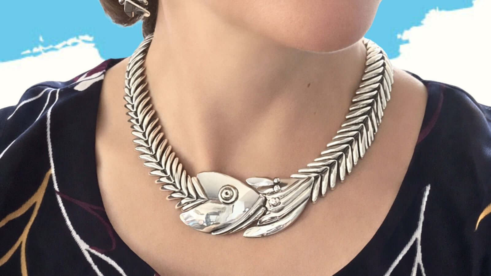 Close-up lifestyle view of a woman wearing the iconic D'Molina articulated sterling silver fishbone necklace