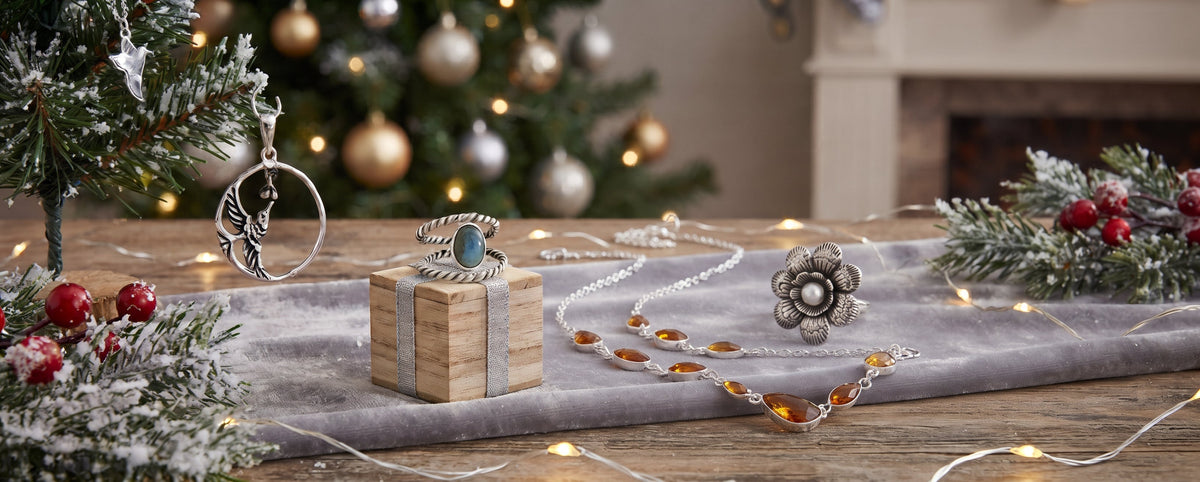 A festive holiday tabletop display featuring a collection of silver jewelry.