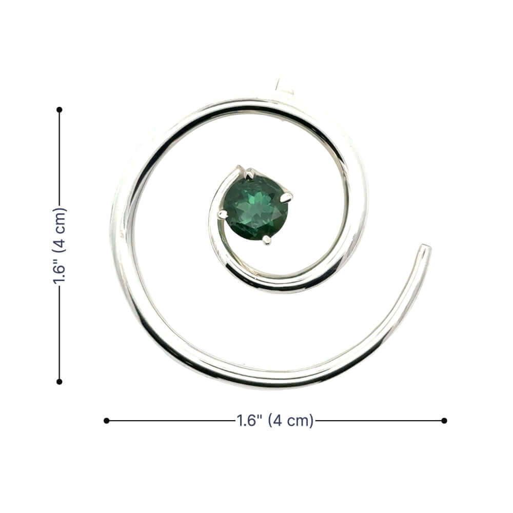 Overhead view of a circular silver spiral pendant with a green tourmaline center showing dimensions of 1.6 inches.