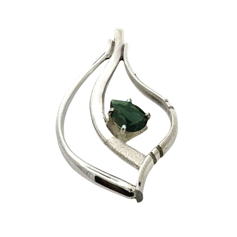 Side profile of a handcrafted silver pendant showing the depth of the metalwork and the secure prong setting of the green peridot.