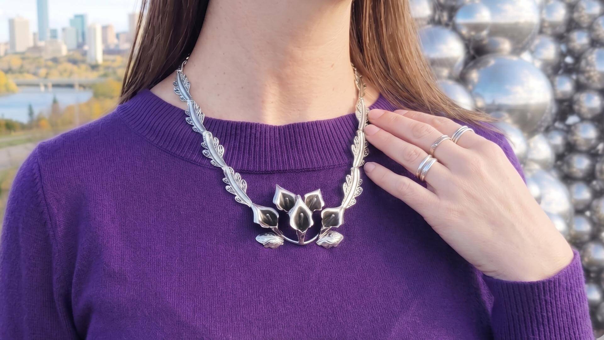 Detailed view of a woman in Edmonton, Canada wearing an intricate nature-inspired 925 sterling silver statement necklace, curated by a Mexican-Canadian small business.