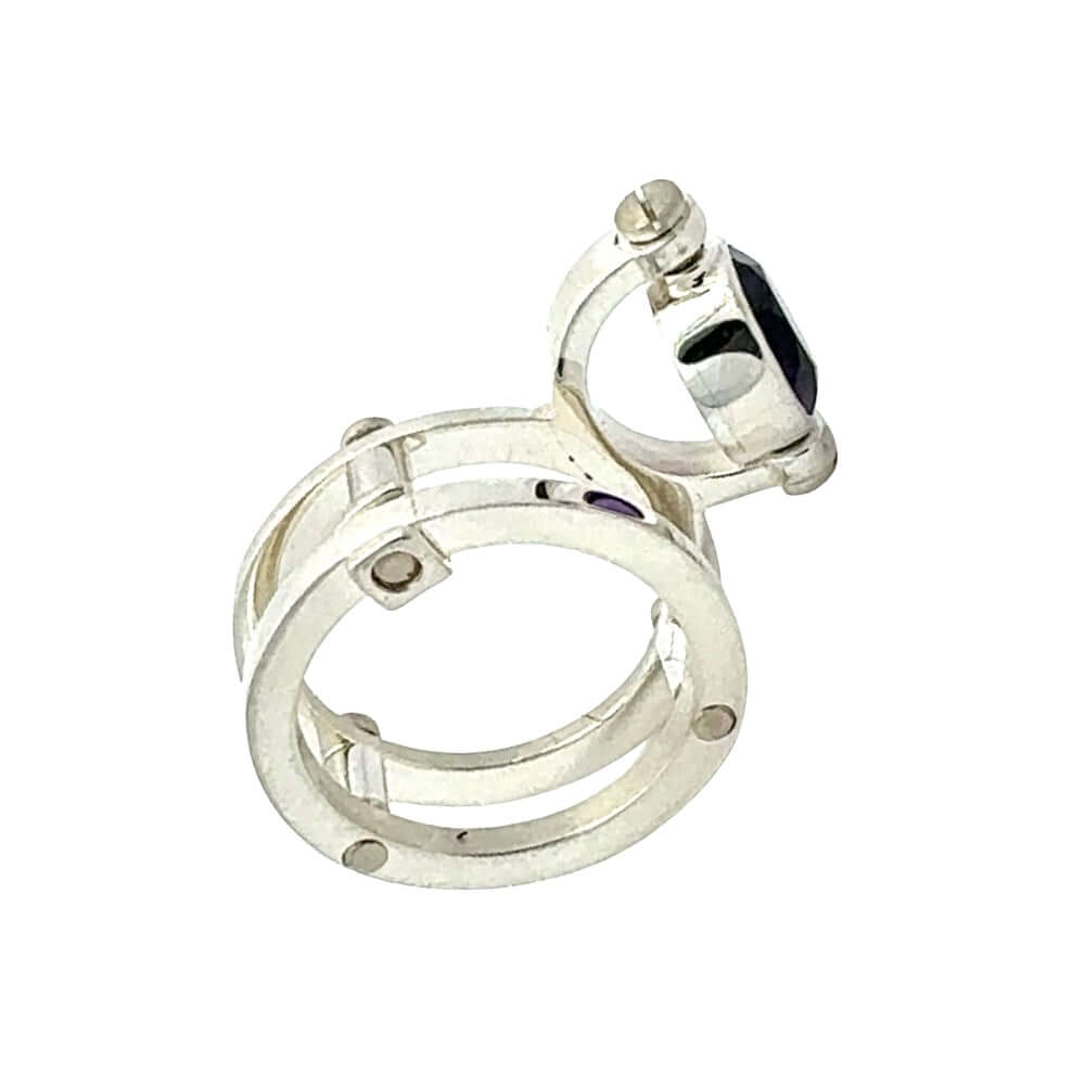 Silver ring with embedded gemstones on a white background