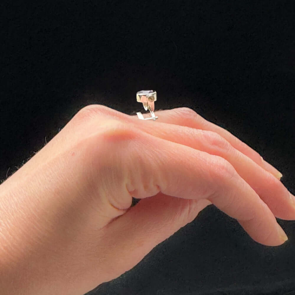 950 silver ring on a finger against a black background