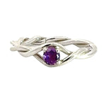 Silver ring with a purple gemstone on a white background