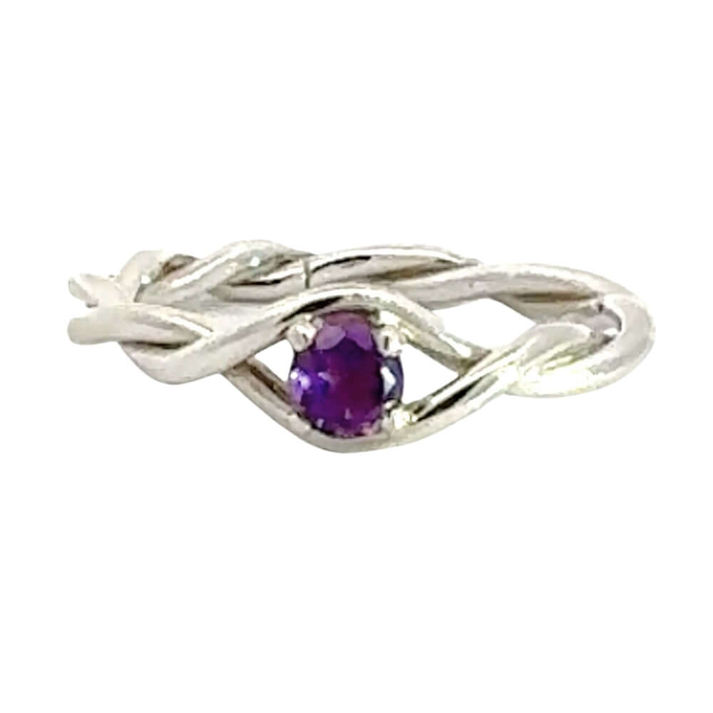 Silver ring with a purple gemstone on a white background