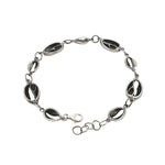 Silver bracelet with black oval stones on a white background