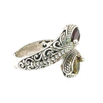 Silver ring with intricate designs on a white background