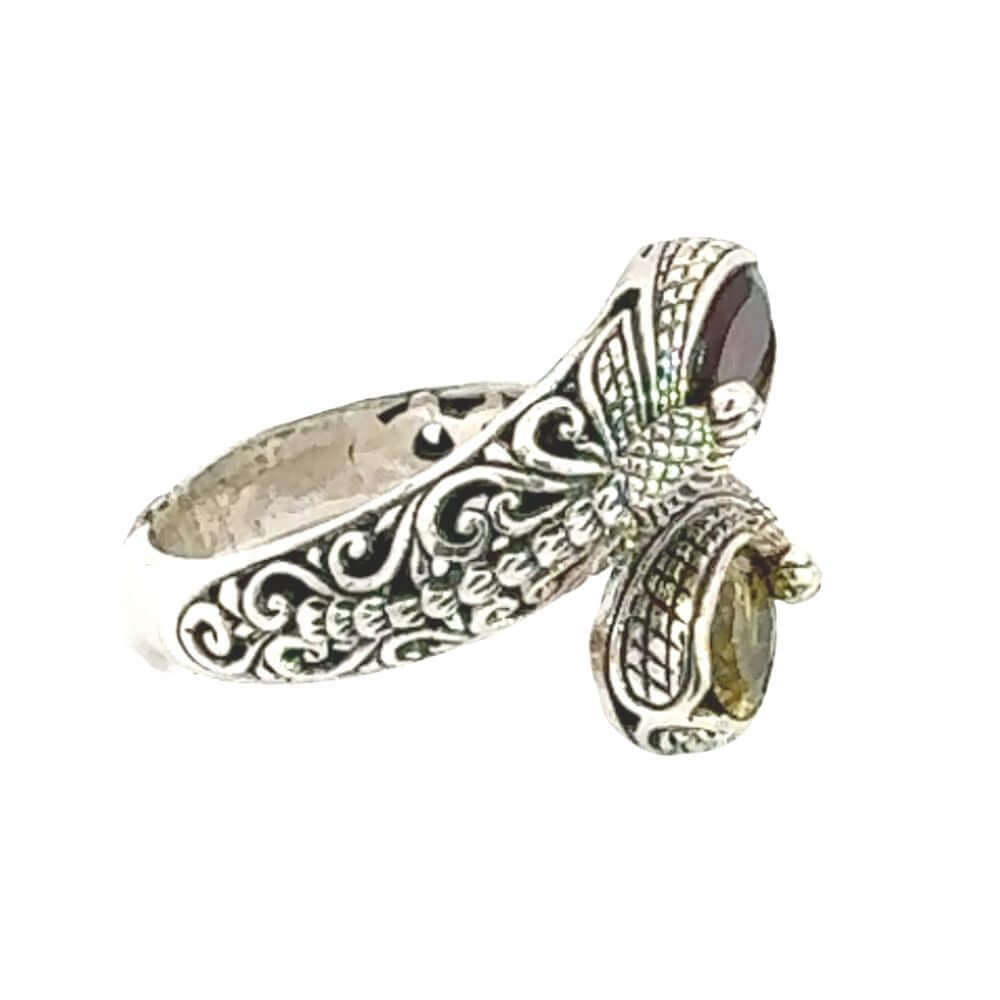 Silver ring with intricate designs on a white background