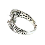 Silver ring with intricate designs on a white background