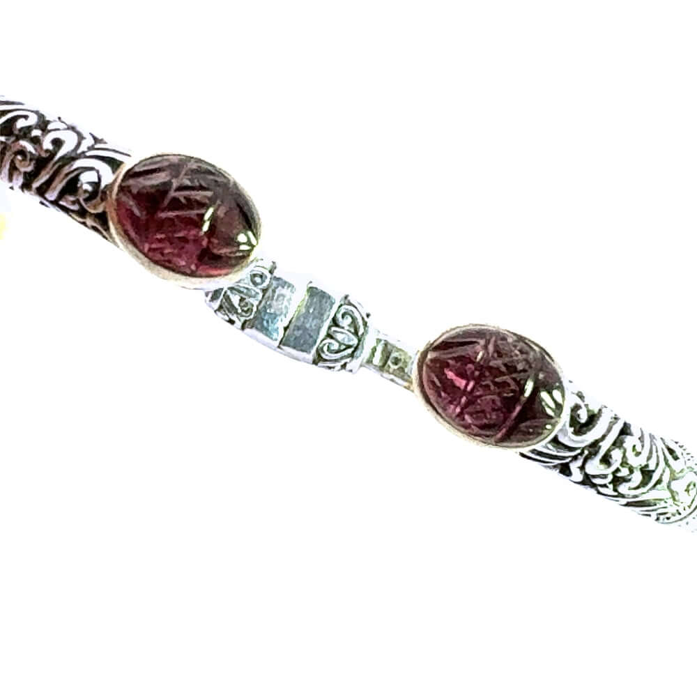Bracelet with carved amethyst and silver patterns on a white background