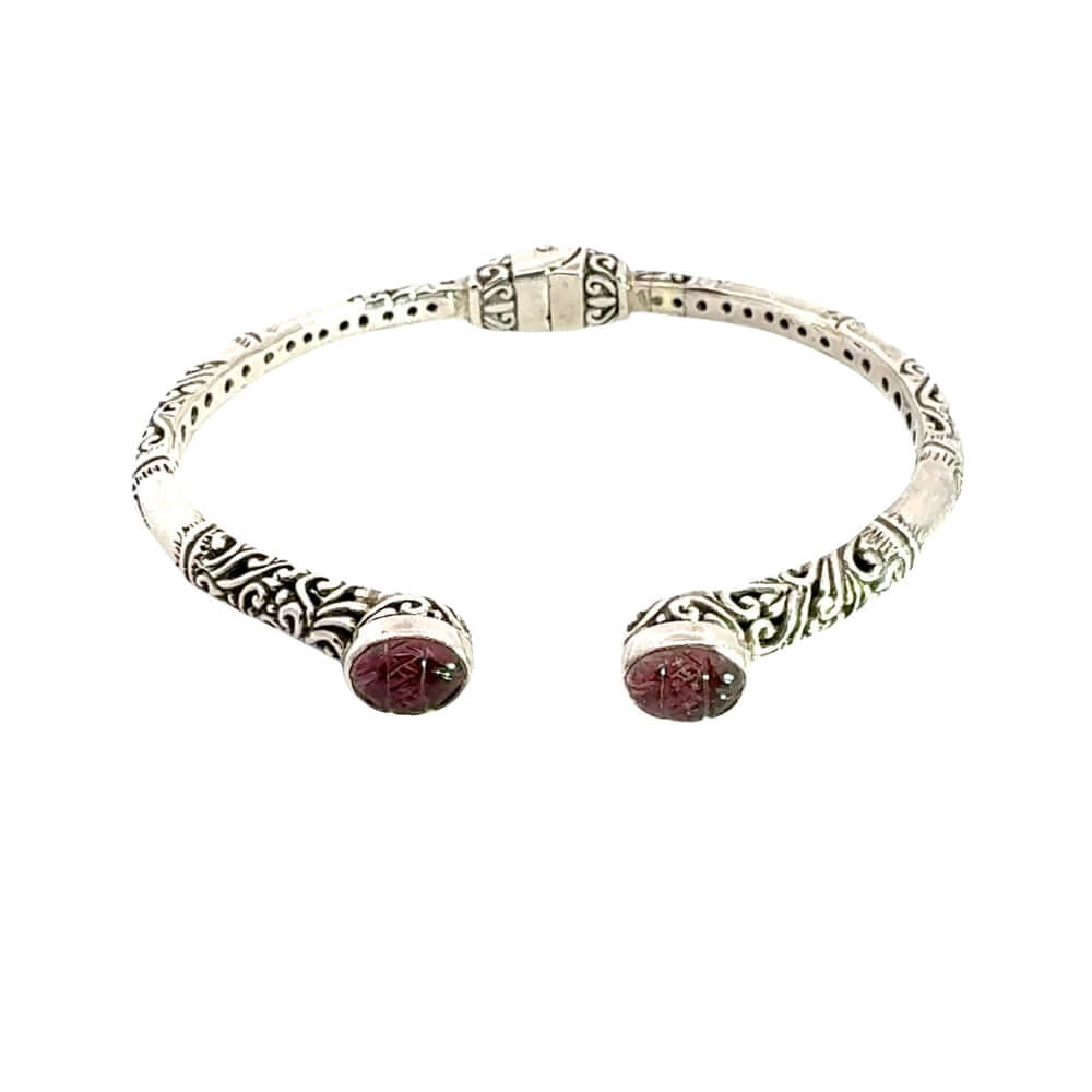 Silver bracelet with carved amethyst on a white background