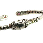 Silver bracelet with intricate designs on a white background