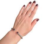 Hand wearing a Taxco silver cuff-bracelet with carved amethyst 