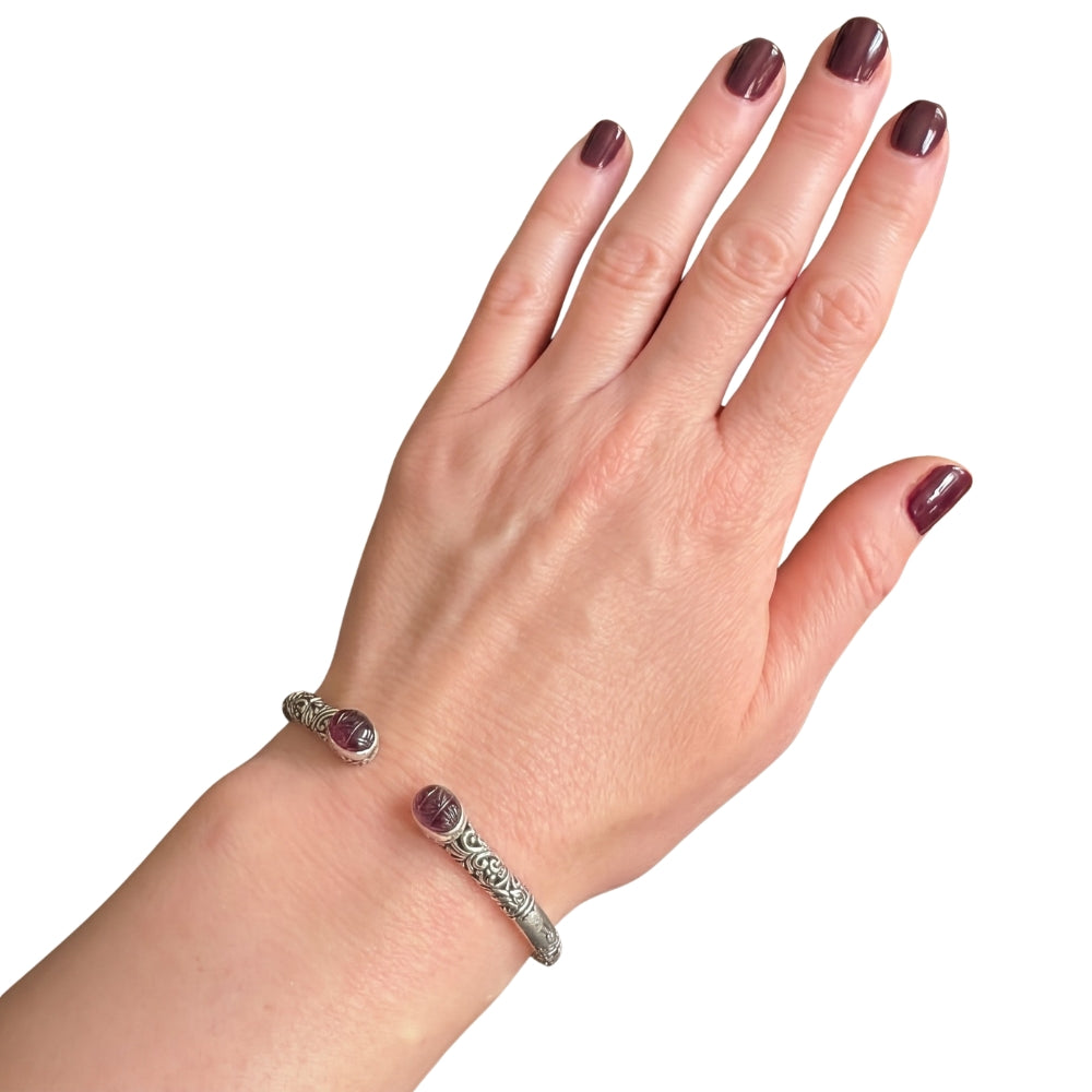 Hand wearing a Taxco silver cuff-bracelet with carved amethyst 
