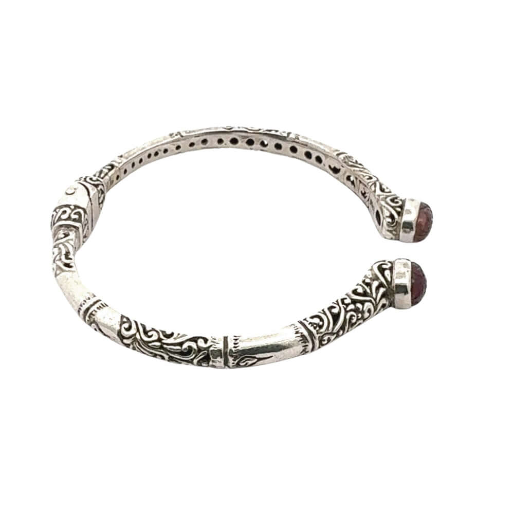 Silver bracelet with intricate designs on a white background