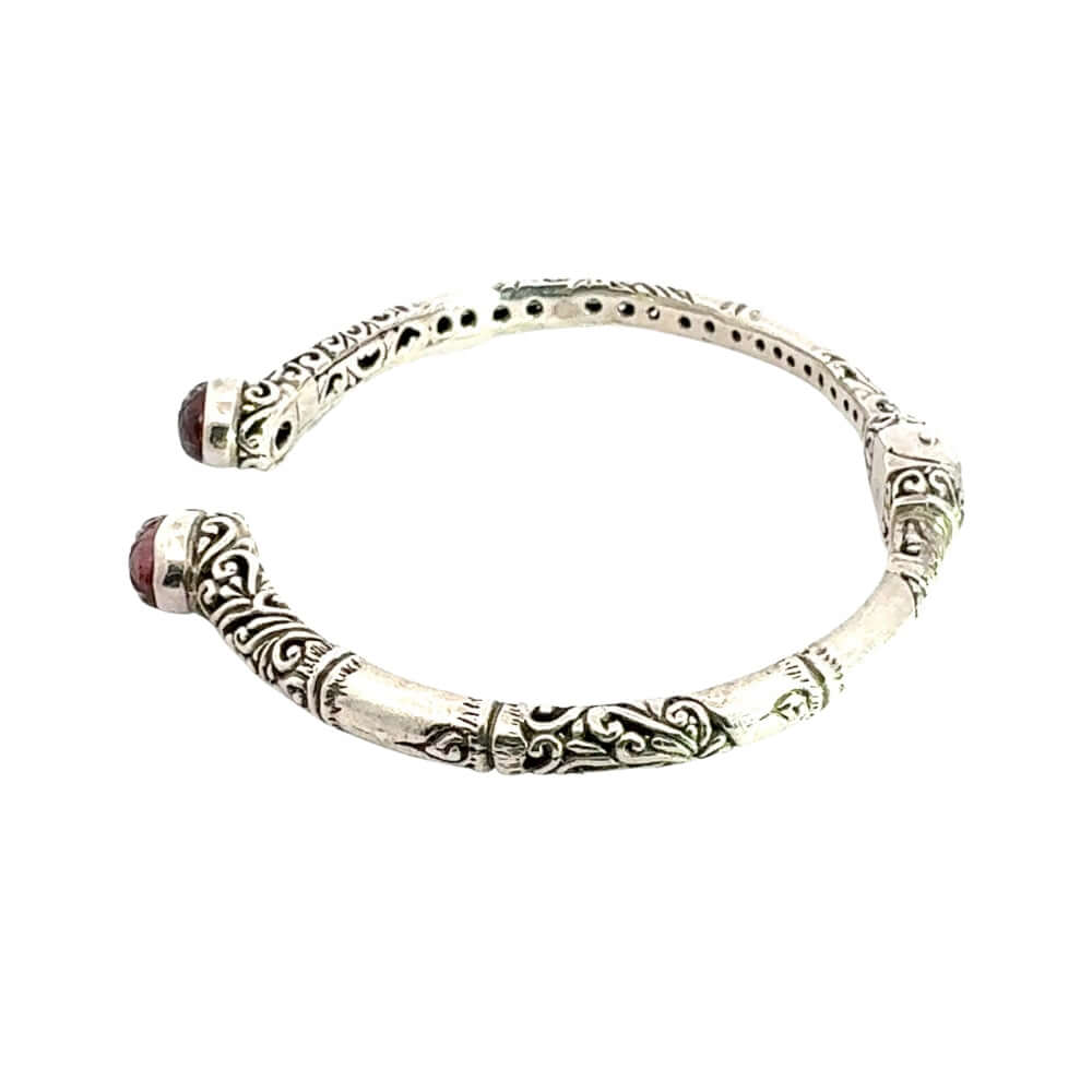 Silver bracelet with intricate designs on a white background