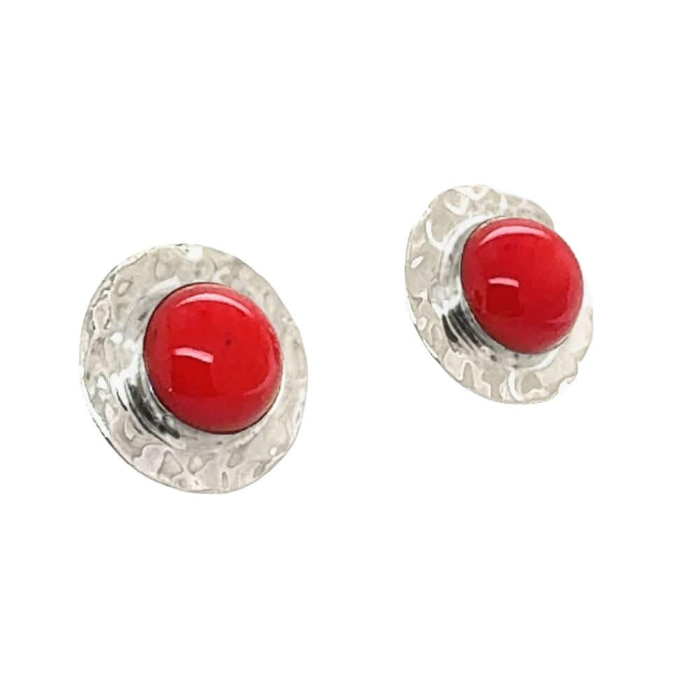 Pair of earrings with red coral and silver settings on a white background