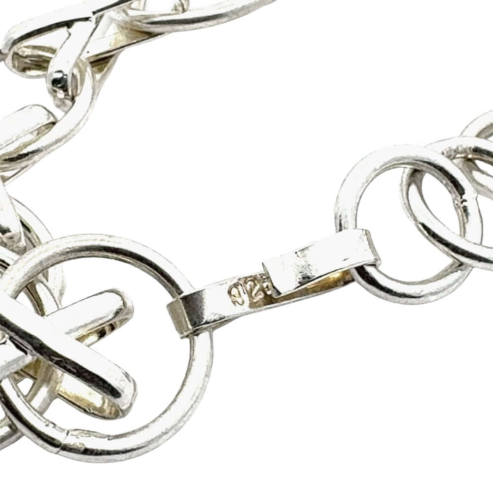 Close-up of a silver bracelet with interlocking rings on a white background