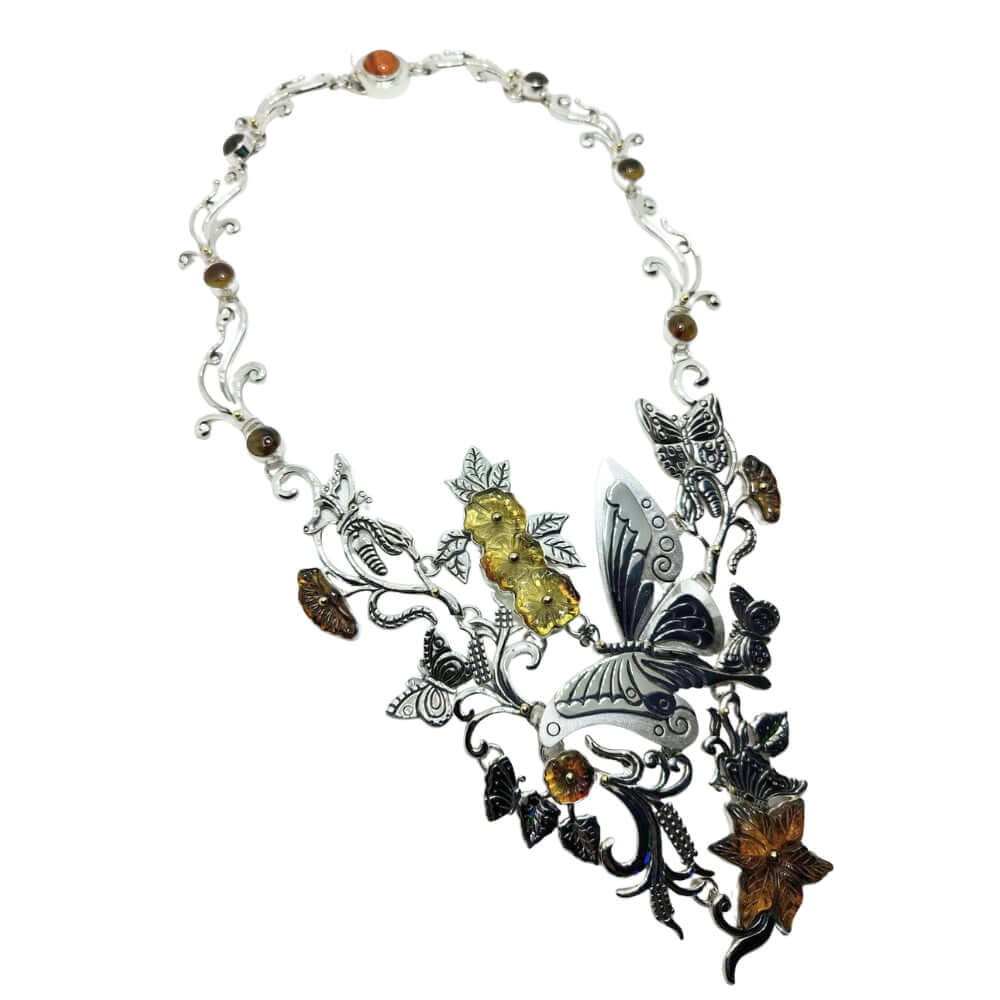 Ornate necklace with butterfly and leaf designs on a white background