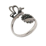 Silver ring with butterfly and flower design on a white background
