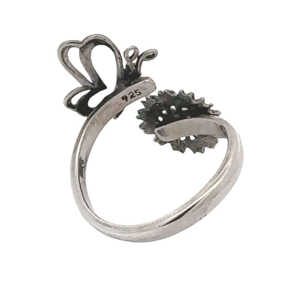 Silver ring with butterfly and flower design on a white background