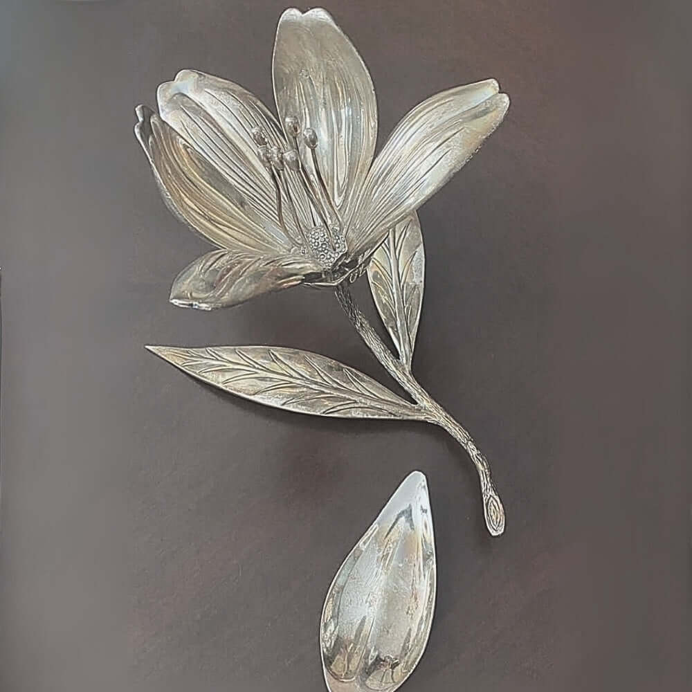 Silver flower and leaf ashtray on a dark background