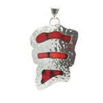 Back of silver pendant with red coral on a white background