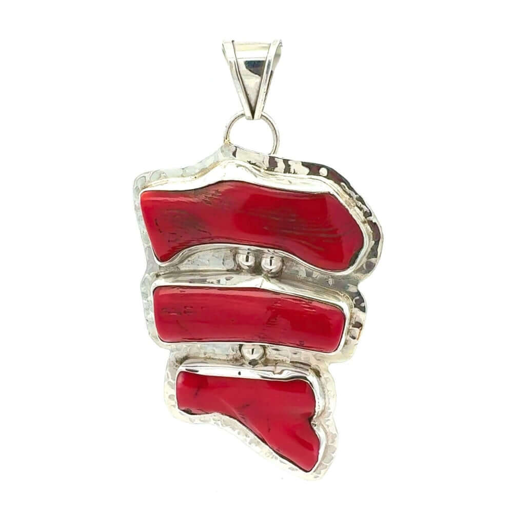 Red coral pendant with silver setting on a white background