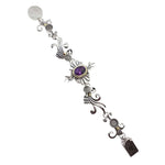 Decorative silver bracelet with purple gemstone on a white background