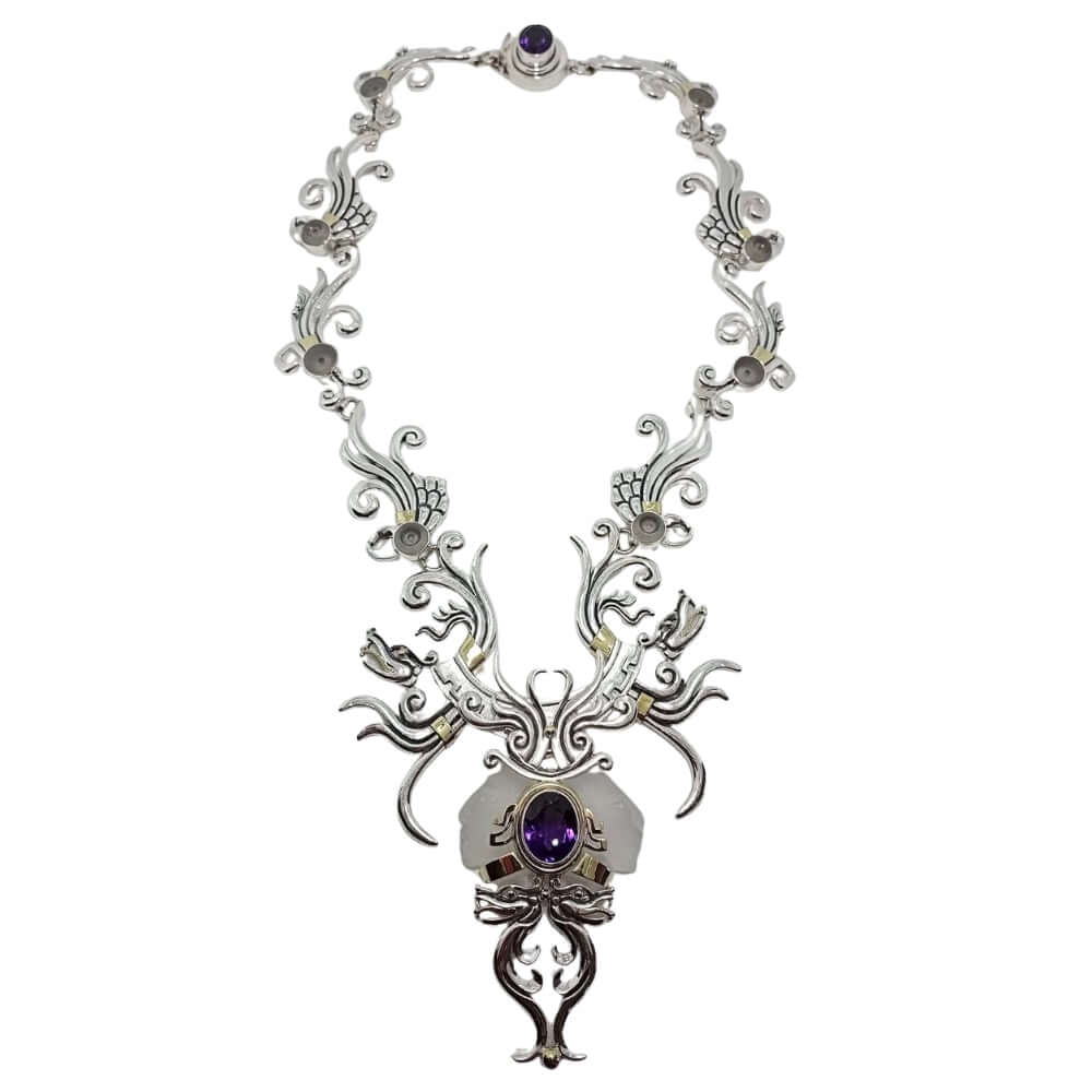 Ornate silver necklace with purple gemstones on a white background