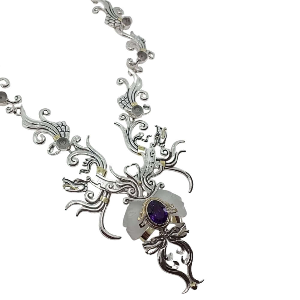 Ornate silver necklace with a purple gemstone on a white background lateral view