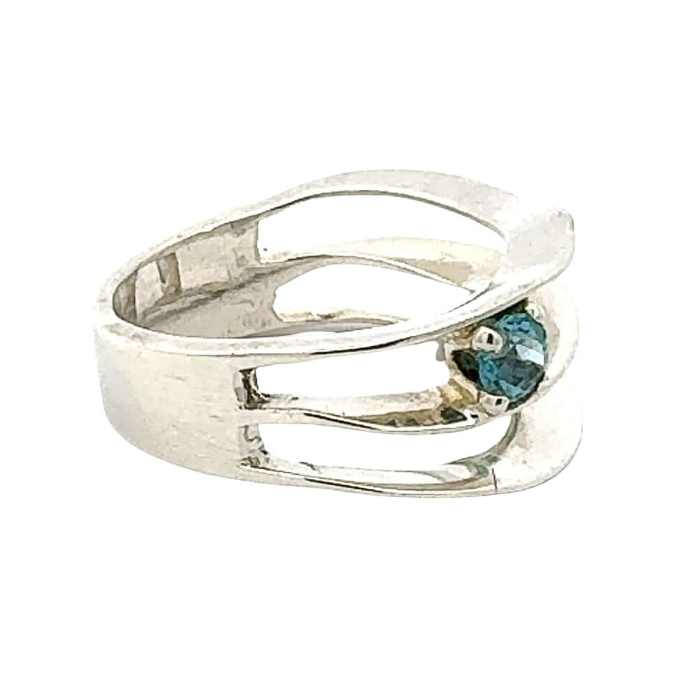Taxco silver ring from the side with a blue topaz gemstone on a white background
