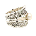 Taxco Silver ring with textured design and a pearl on a white background