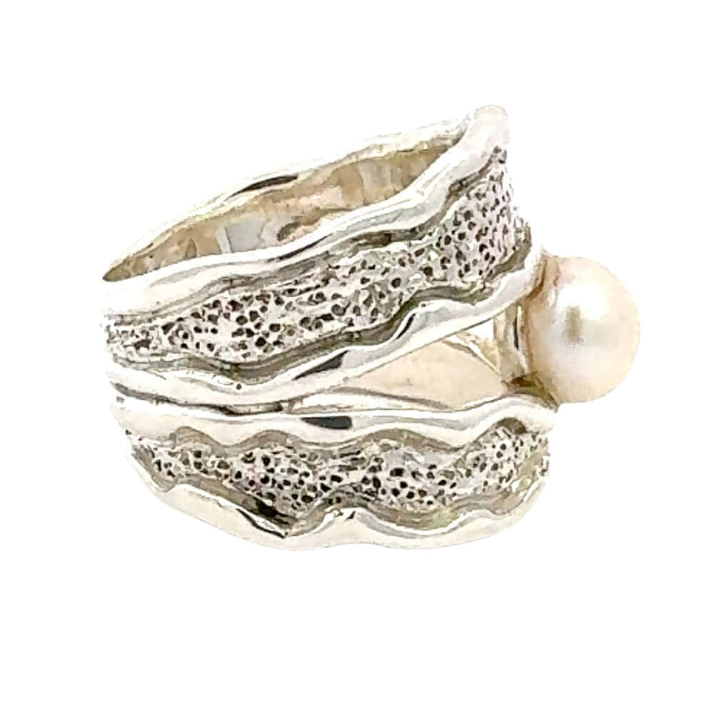Taxco Silver ring with textured design and a pearl on a white background