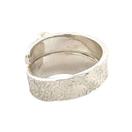 Silver ring with a textured surface on a white background