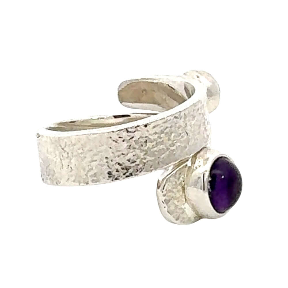 Silver ring with a purple gemstone on a white background