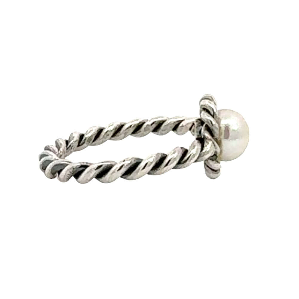 Silver twisted ring with a pearl bead on a white background