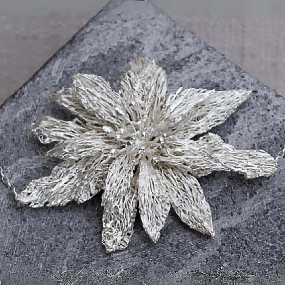 Silver flower-shaped headpiece on a textured gray surface