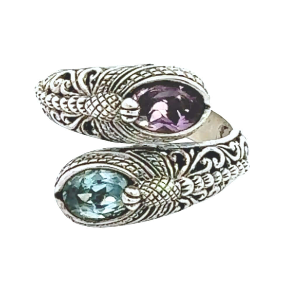 Silver ring with purple and blue gemstones on a white background