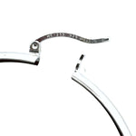 Close-up of a silver earring with 'Mexico' inscription on a white background