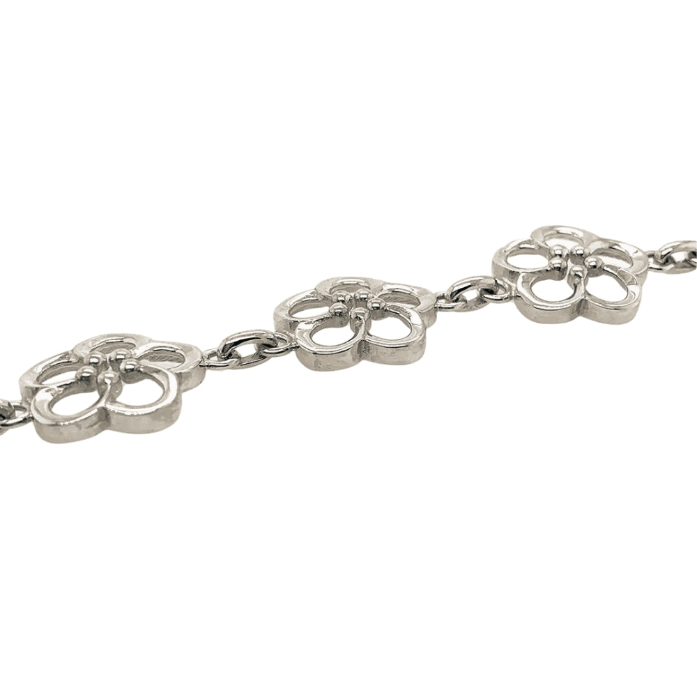 A silver bracelet featuring repeating openwork floral-like links connected by short chain segments, shown on a plain white background.