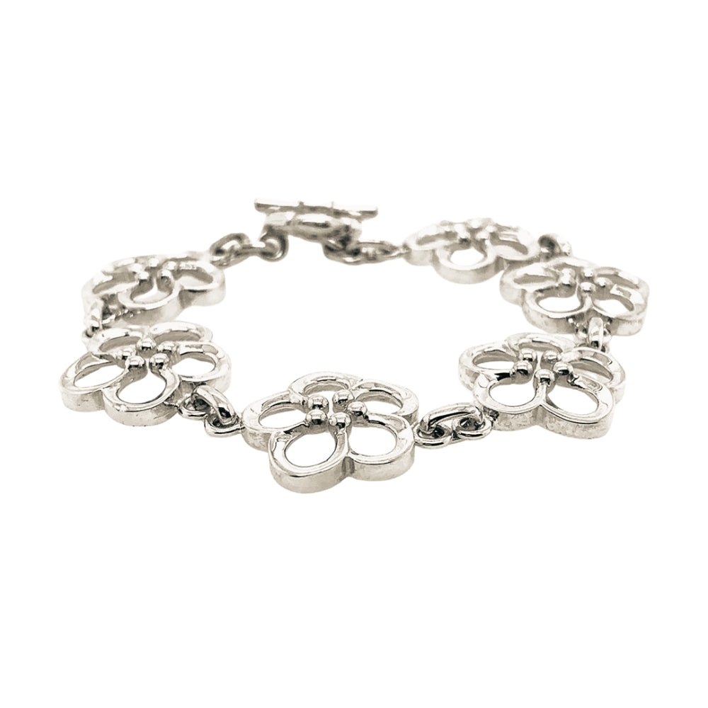 A silver bracelet featuring a series of openwork floral-like links connected by small chain segments, with a toggle clasp, shown on a plain white background.