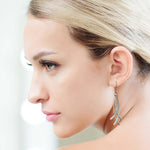 Close-up of a woman wearing a silver earring with a blurred background