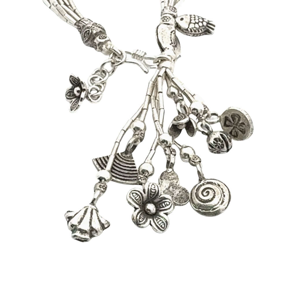Silver necklace with various charms on a white background