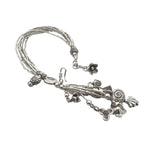 Silver bracelet with various charms on a white background