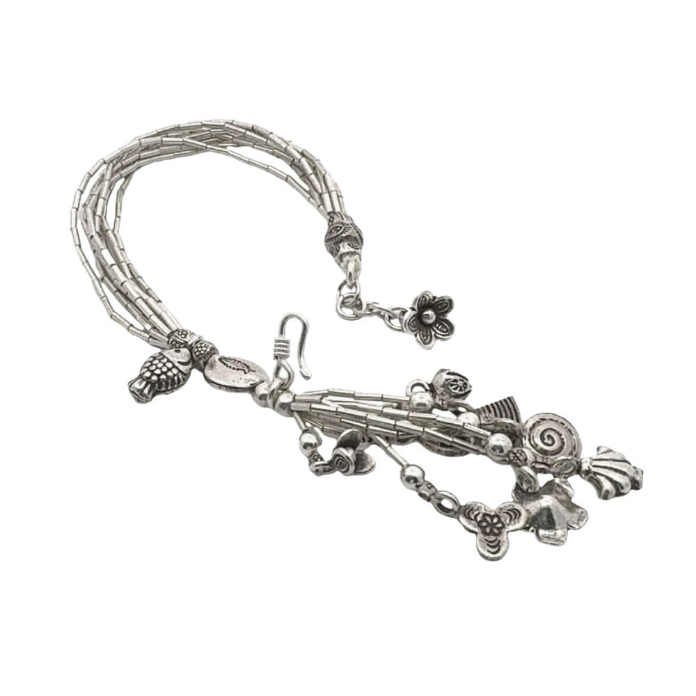 Silver bracelet with various charms on a white background