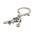 Silver bracelet with various charms on a white background